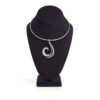 19K white gold collar necklace with a swirl pendant adorned with diamonds, pink sapphires, and garnets on a black velvet mannequin.