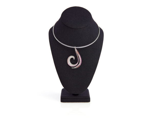 19K white gold collar necklace with a swirl pendant adorned with diamonds, pink sapphires, and garnets on a black velvet mannequin.