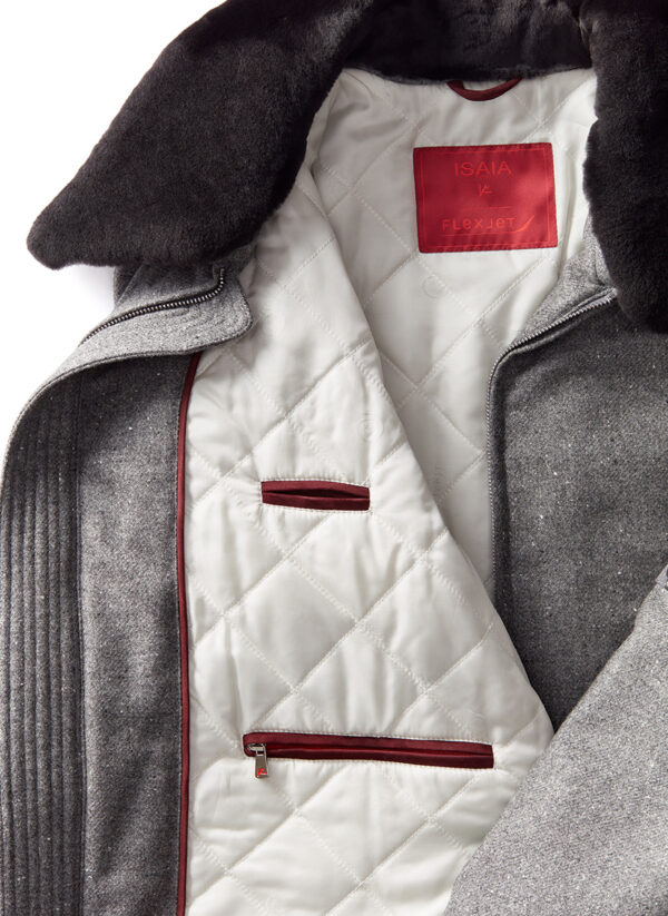 Jacket interior lined with white quilted fabric. There are two merlot-colored pockets: one suede and one with a zipper. The zipper pocket is located toward the bottom, and the suede pocket is situated above it. The zipper is silver with a small red ISAIA® logo. At the top of the jacket's interior, there is a red rectangular label with the text “ISAIA” and “Flexjet.”
